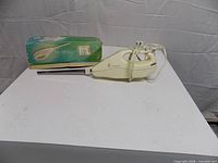 Knife with blade attached alongside original box