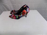 Side view of both heels showing floral pattern, bow, and heel height