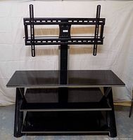 Front view showing glass top, two lower shelves, and mounted bracket