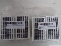 Two sealed packs of replacement refrigerator air filters showing barcode labels and model info