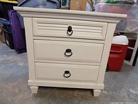 Front view of nightstand showing three drawers and hardware