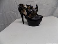 Oblique front view showing criss-cross straps, platform and overall style