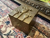 Front view of brass box showing lid design and patina