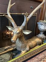 Left-side view of full sculpture beside fireplace with measuring tape for length reference