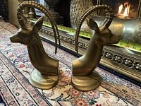 Pair of brass antelope head bookends front angled view