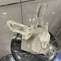 Quartz crystal cluster placed on green marble box lid