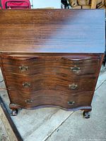 Full view of desk closed showing serpentine drawers and claw feet