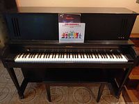 Front view of black Baldwin upright piano with sheet music displayed