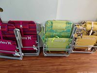 Four folded Hurley chairs showing different fabric patterns and straps