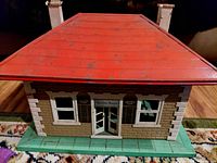 Tin Lionel station front view showing red roof, windows and green base