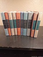 Group shot of ten cloth-bound hardcovers standing upright