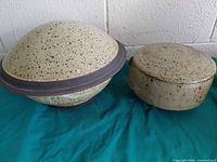 Two lidded stoneware bowls side by side showing overall form and color