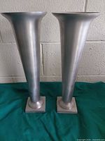 Front view of pair of silver aluminum vases showing height and shape