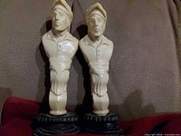 front view of both celluloid bust figurines on black bases