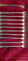 All 11 cocktail forks aligned showing full length and tines