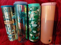 Group shot of four Starbucks stainless steel tumblers showing all designs and lids