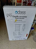 Front of boxed Odass towel warmer showing branding and model