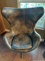 Front view of one brown leather swivel chair