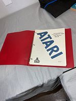 Front cover sheet of Atari service manual inside red binder