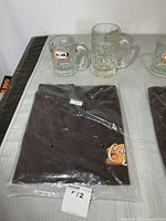 Lot overview showing two A&W mugs and packaged black T-shirt