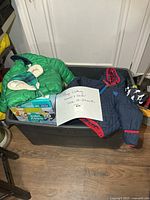 Tote containing visible boys clothing items and note showing sizes
