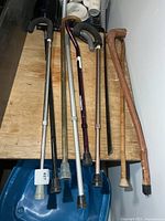 Group of canes and shoe horn on wooden surface