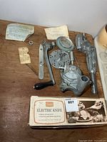 Electric knife box and disassembled aluminum food strainer parts on tabletop