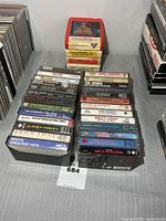 Overview of two stacks of cassettes and 8-tracks on table