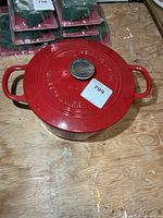 Lidded red Dutch oven showing overall form and both side handles