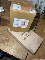 Two sealed cardboard boxes containing the clocks