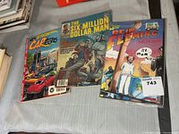 Three comics laid out: CarToons, Six Million Dollar Man (bagged), Reid Fleming (bagged)