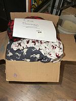 Box containing assorted crib bedding pieces