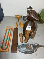 group shot of all items including cribbage boards, dog sculpture, gavel, duck candleholder, etc