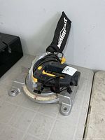 Full view of miter saw with dust bag and base
