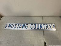 Full view of Mustang Country metal sign on table