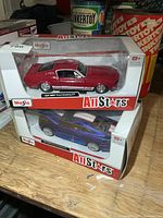 Two Maisto AllStars diecast Mustangs in boxes stacked