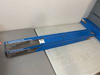 Full view of unopened blue box for 15" magnetic floor sweeper