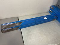 Stack of blue retail boxes containing 15 in magnetic floor sweeper