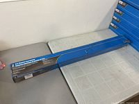Full view of sealed blue box containing magnetic floor sweeper