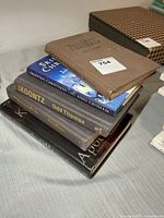Stack of five hardcover novels showing vintage book, Skipping Christmas, Odd Thomas and additional titles