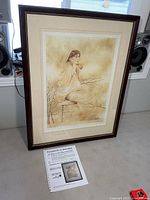 Framed Angela Luck print with appraisal document on table
