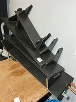 Stacked black painted wooden shelves showing side supports