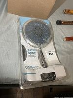 Front of sealed package showing Home Basics Jumbo Spray Shower Massager
