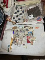 Overall lot with tin case, stamp sheet, envelopes and loose stamps on table