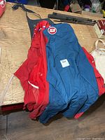 Stacked aprons showing blue IGA and red aprons