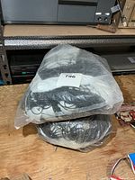 Two plastic-bagged tennis nets stacked