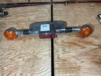 Full view of chrome rear light assembly with orange signal lenses and red central lens