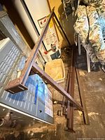 Overall view of brown metal bed frame parts leaning against furnace and wall