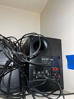 Rear of Cambridge SoundWorks subwoofer showing bass port, control panel and cabling