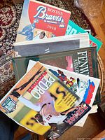 Stack of assorted baseball programs, pop-up book visible
